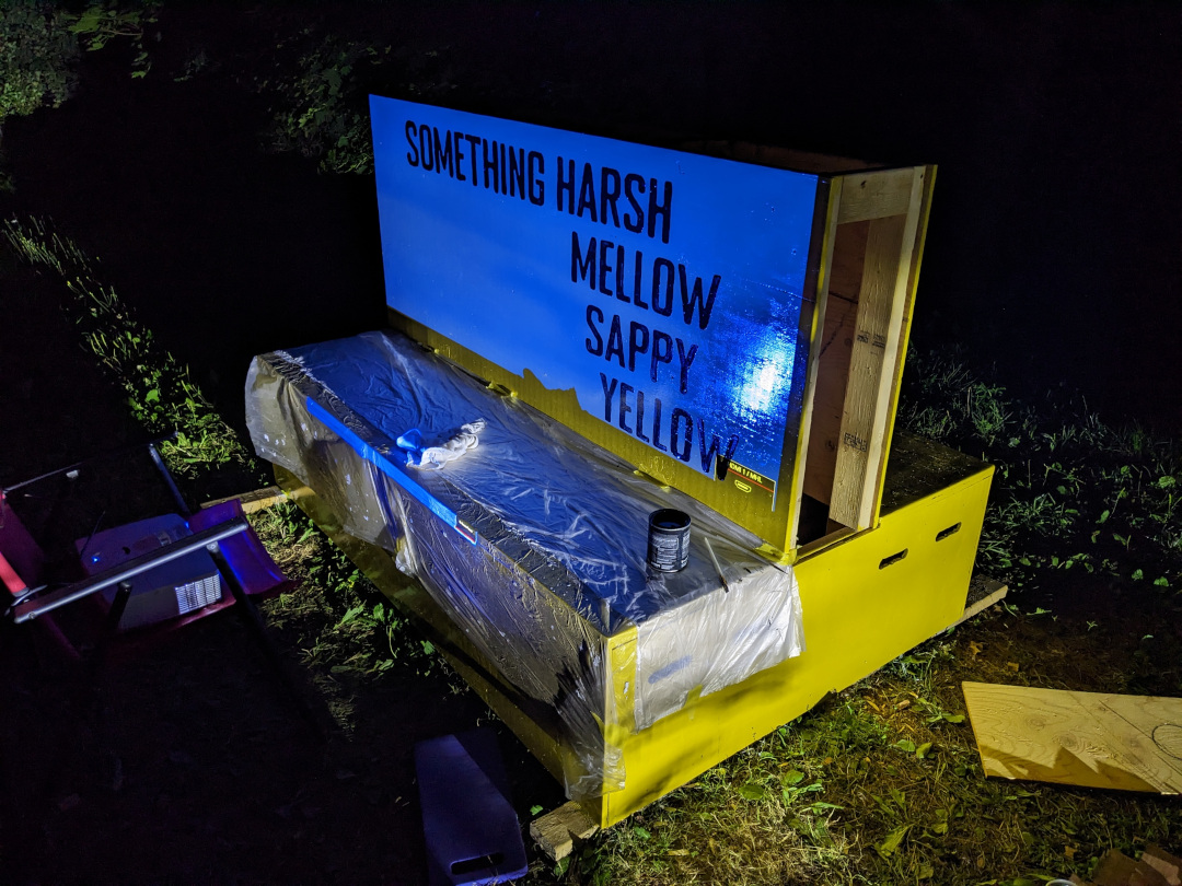 Projector shining letters to paint on the bench.